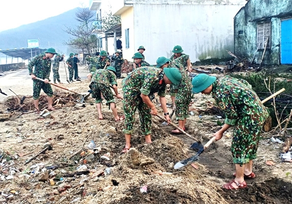 Cán bộ, chiến sĩ khơi thông tuyến đường ven biển thuộc tổ dân phố Đồng Dương, thị trấn Lăng Cô, huyện Phú Lộc, tỉnh Thừa Thiên - Huế. Ảnh: LÊ SÁU.